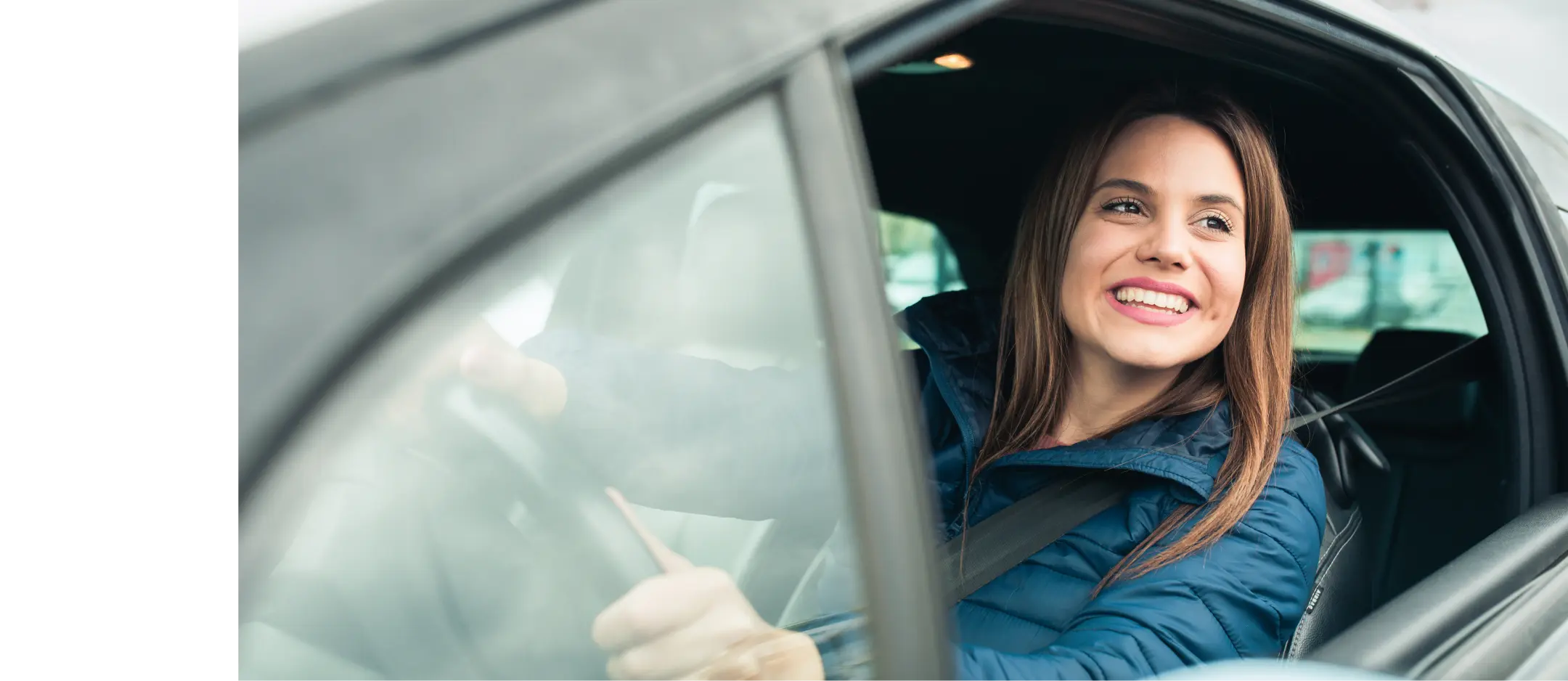 Young woman smiling at the wheel of a car